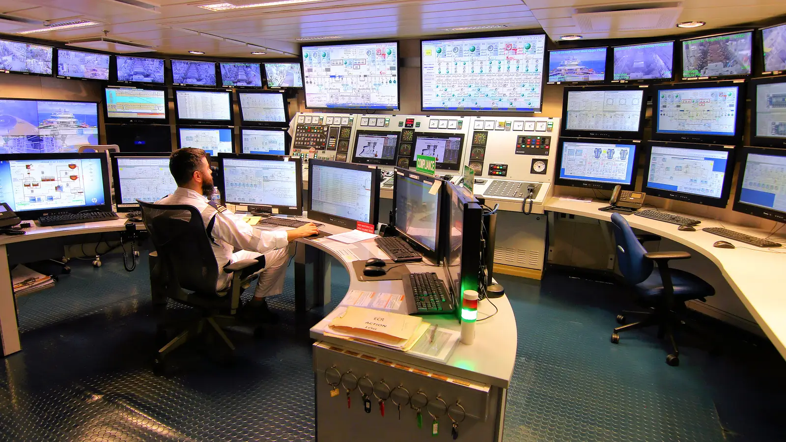 A ship's engine control room with rows of monitoring screens