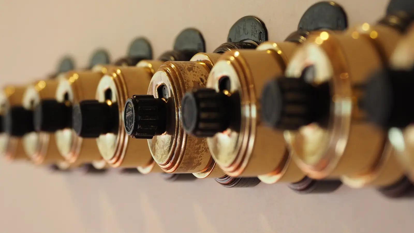 A row of old rotary switches mounted on a wall