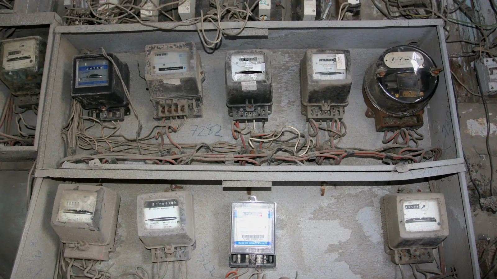A wall of electricity meters with tangled wires