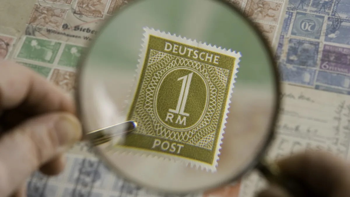 A magnifying glass held over a postage stamp, showing it in close detail