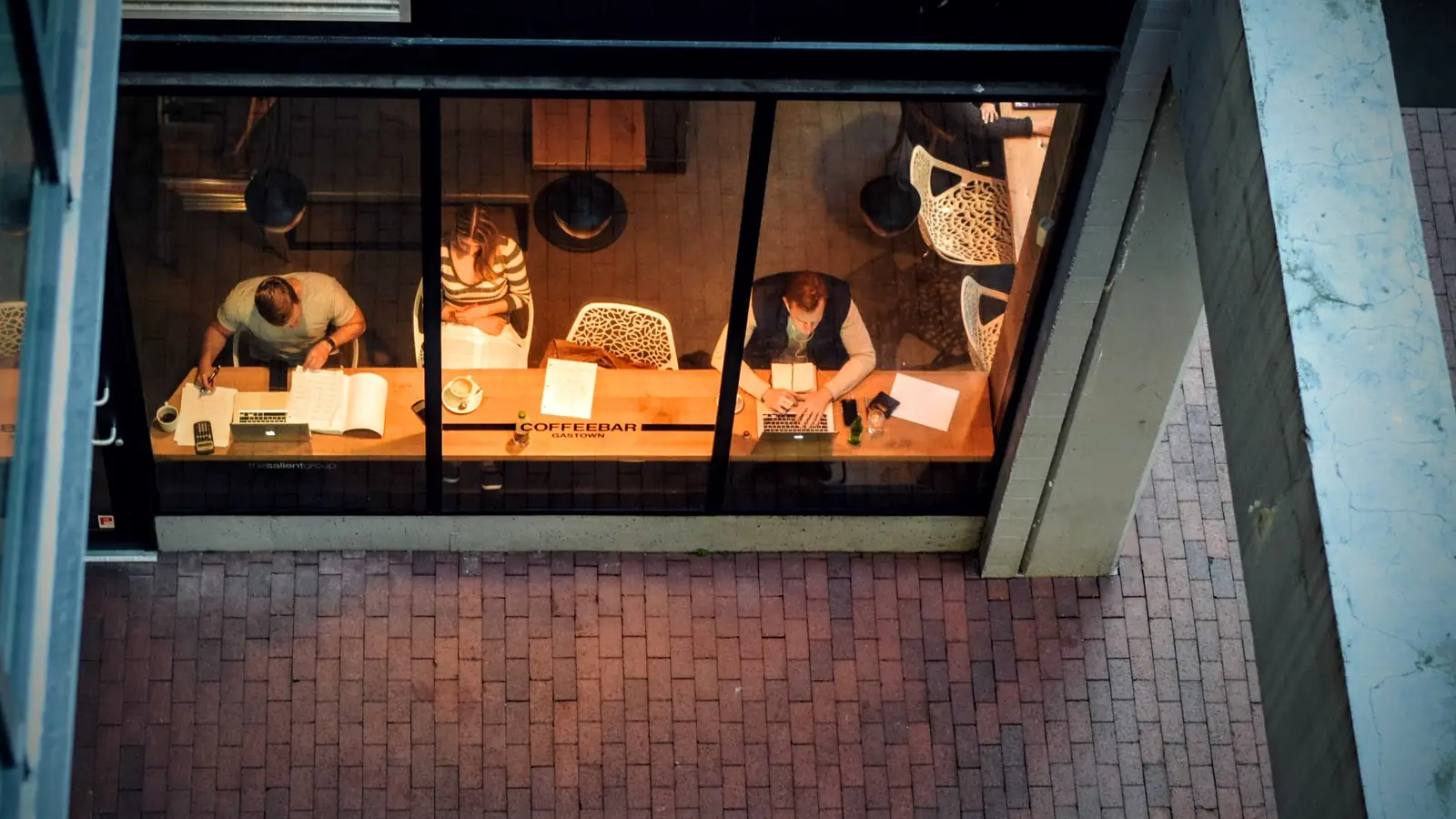 People working on laptops in a busy coffee shop