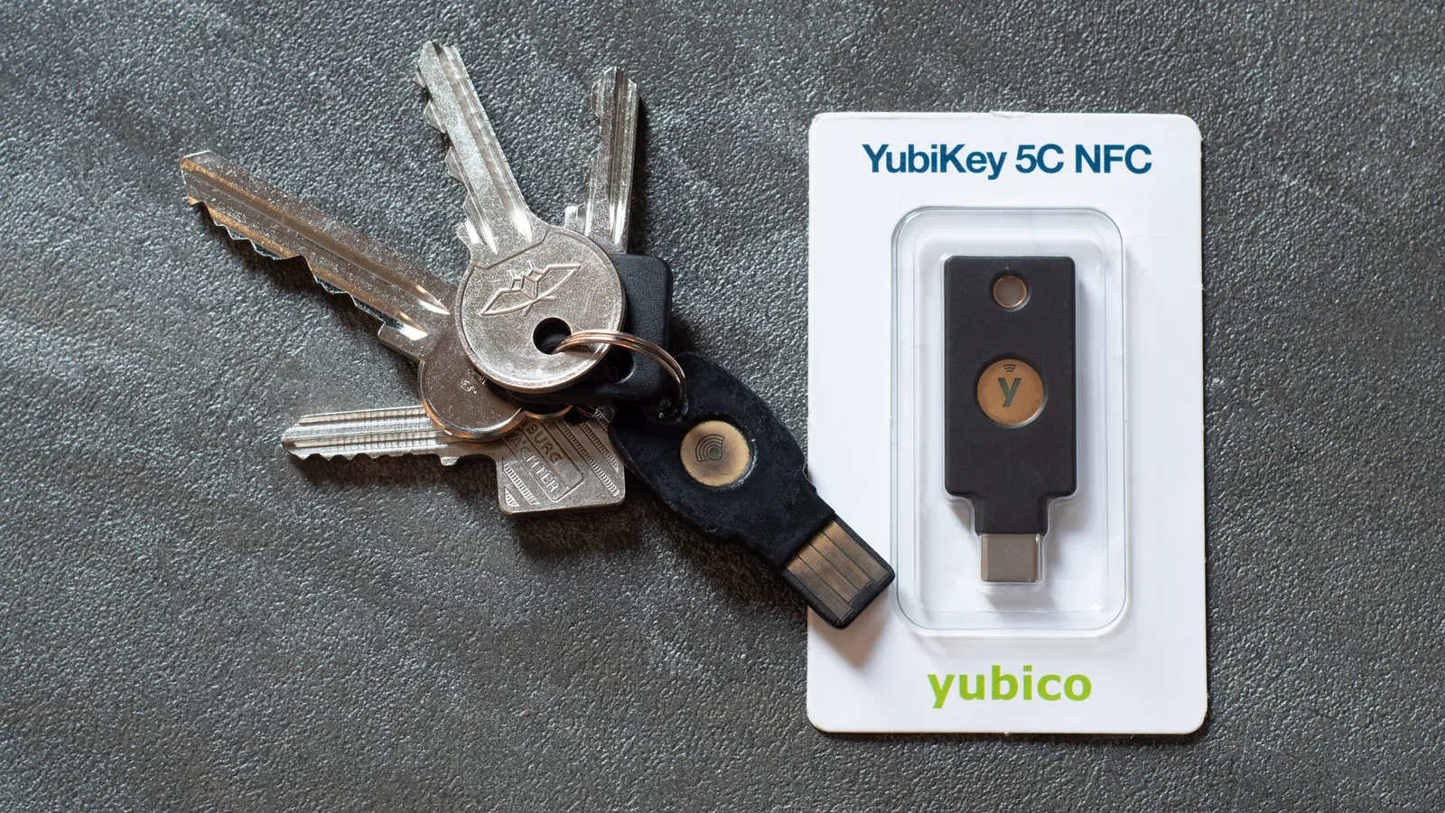 A ring of house keys beside a YubiKey security key in its packaging
